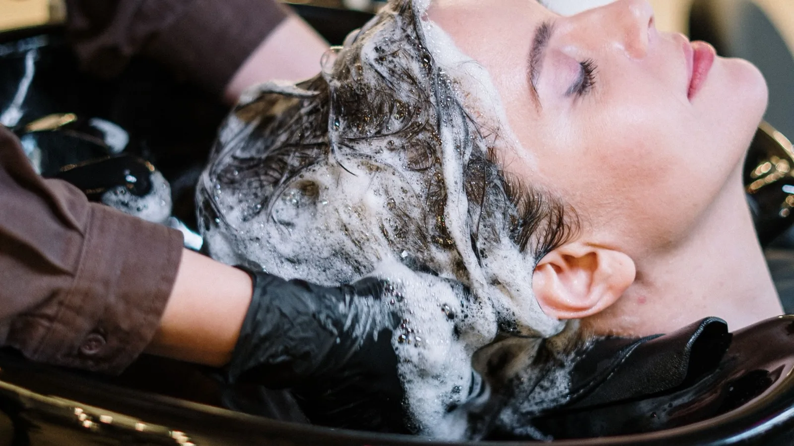 Lavado profesional del cabello en un salón de peluquería