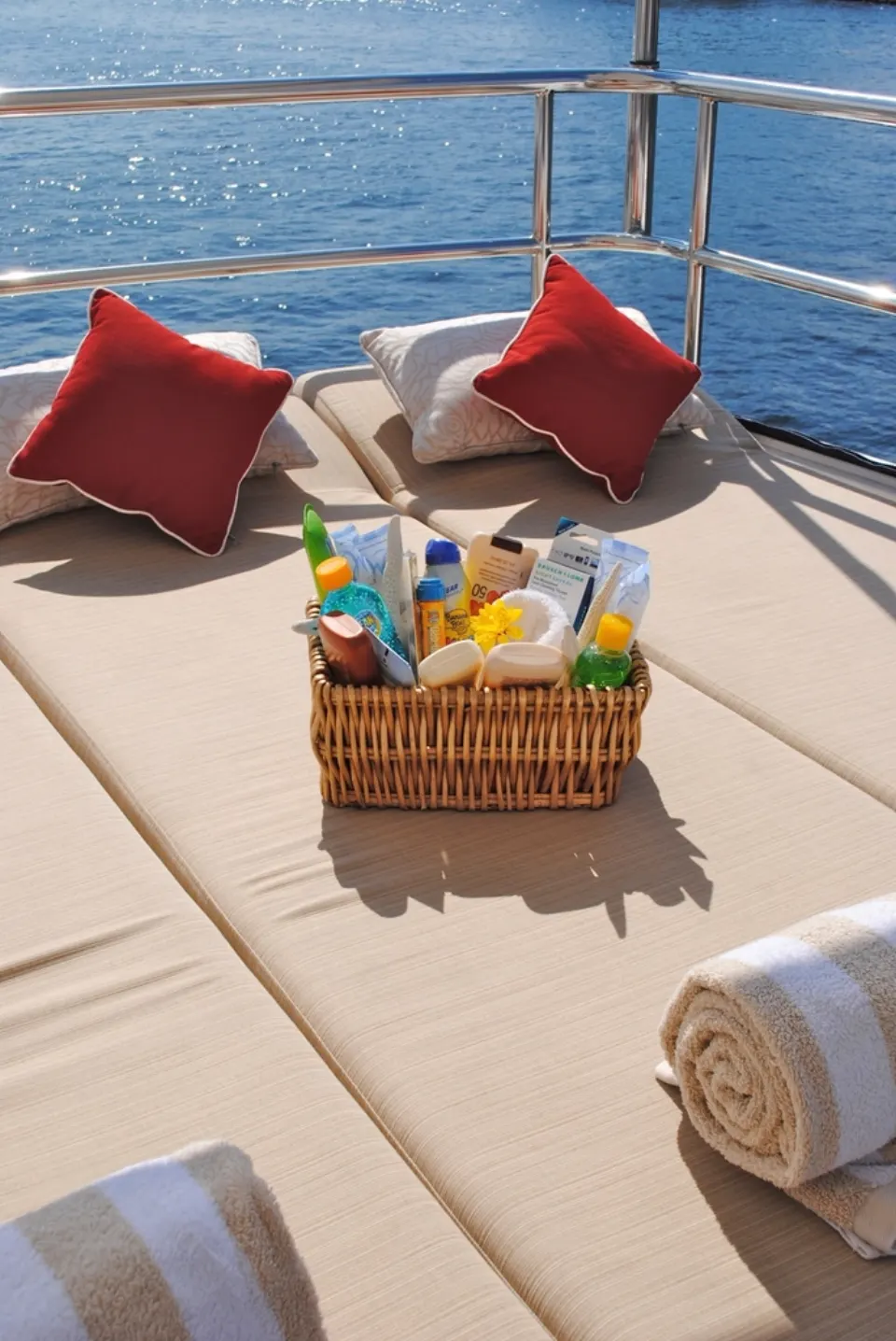 Cesta con productos de cuidado solar junto al mar en verano